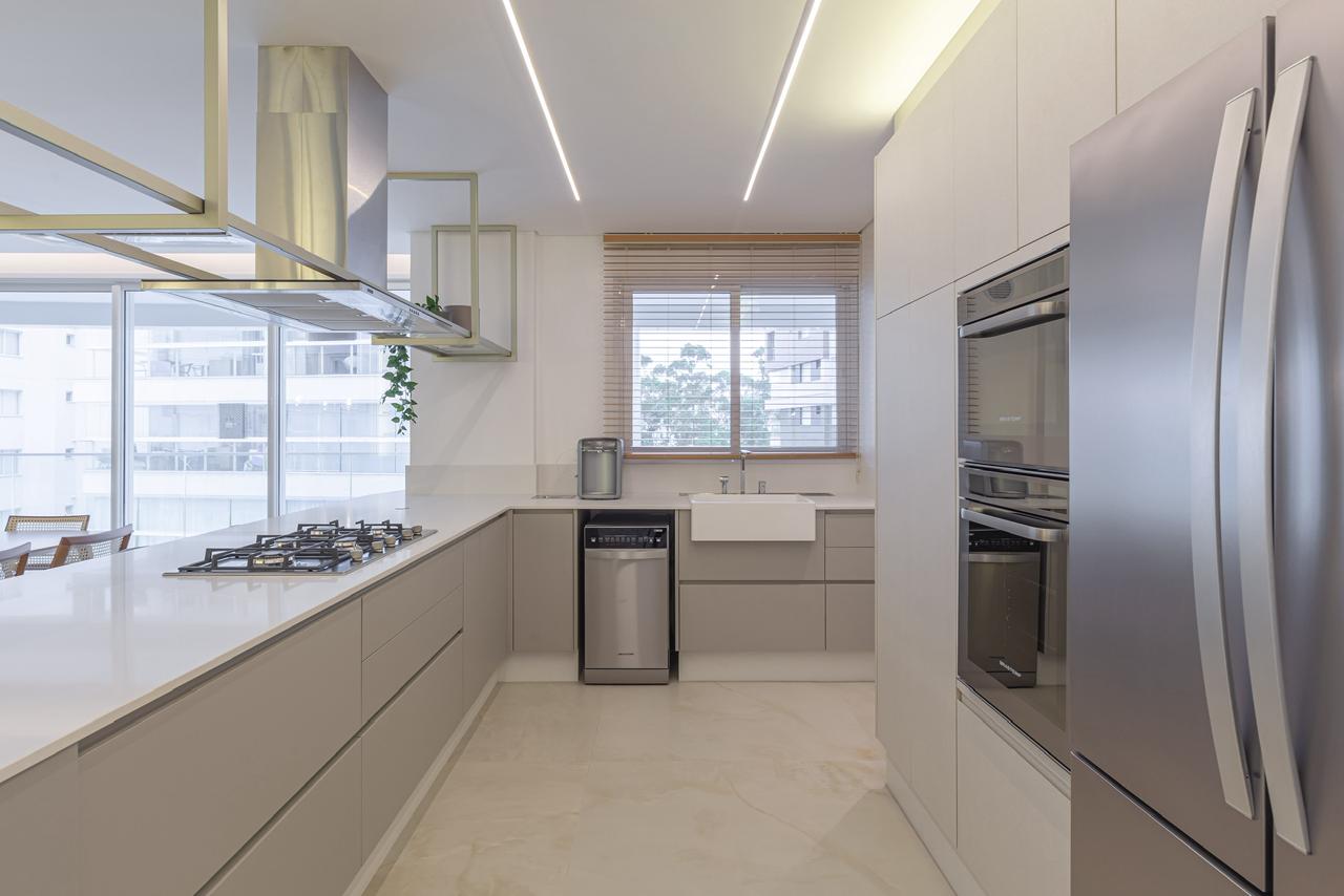 Cozinha linear com marcenaria clara, iluminação no teto e bancada funcional